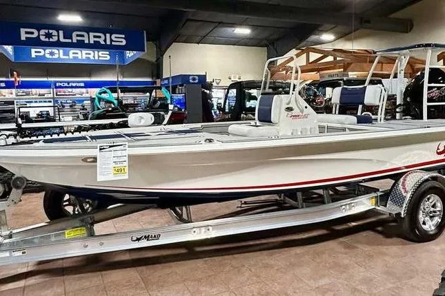 The Image of 2026 Mako 18 Pro Skiff Patriot Edition boat displayed in showroom with Polaris signage. - 0