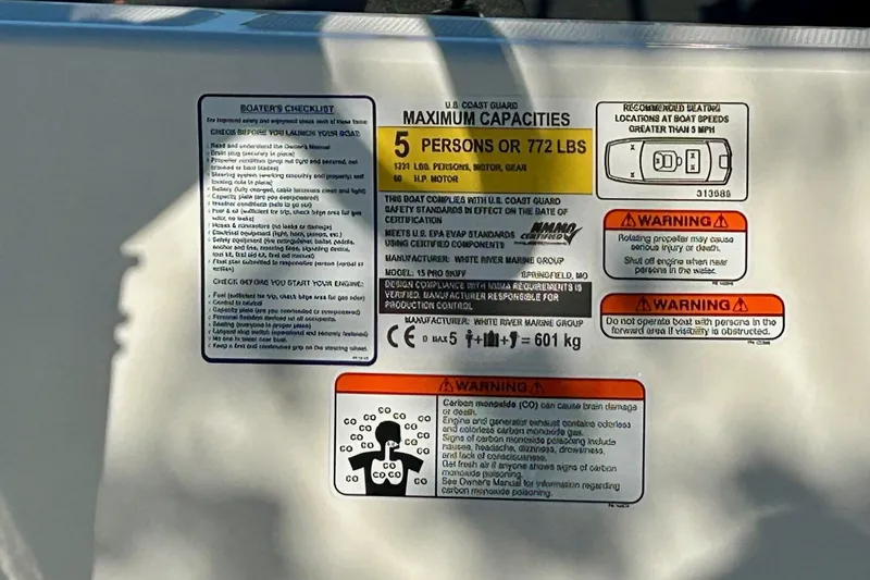 Slide: The Image of 2026 Mako Pro Skiff 15 CC capacity and safety warning labels on boat interior. - 63