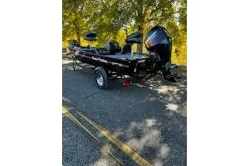Slide: The Image of 2026 Tracker Bass Tracker Classic XL boat parked under trees on a sunny day. - 2