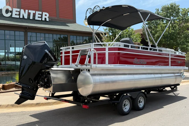 Slide: The Image of 2026 Sun Tracker Fishin' Barge 22 XP3 pontoon boat with Mercury engine, parked outside. - 13
