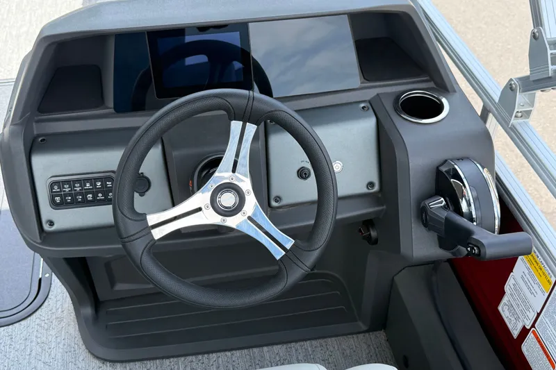 Slide: The Image of 2026 Sun Tracker Fishin' Barge 22 XP3 steering console with modern controls and cup holder. - 16