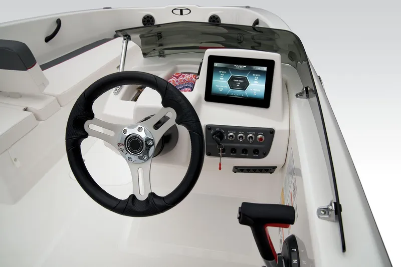 Slide: The Image of 2026 Tahoe T18 boat interior with steering wheel and seating, parked outdoors. - 15