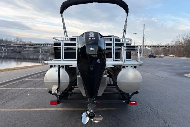 Slide: The Image of 2026 Sun Tracker SportFish 22 XP3 pontoon boat with powerful outboard motor, parked by a river. - 16