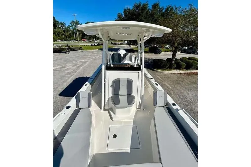 Slide: The Image of 2026 Ranger 2360 Bay boat interior with seating and console, parked outdoors. - 10