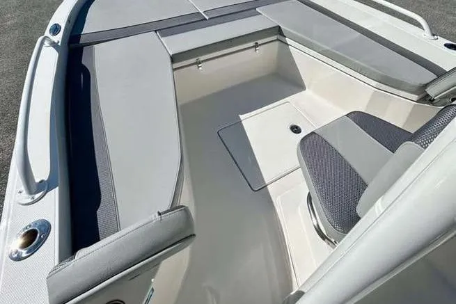 Slide: The Image of 2026 Ranger 2360 Bay boat interior with cushioned seating and storage compartments. - 11