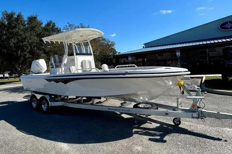Slide: The Image of 2026 Ranger 2360 Bay boat on trailer, parked outdoors under clear blue sky. - 3