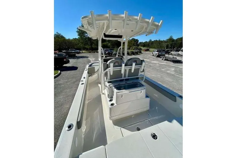 Slide: The Image of 2026 Ranger 2360 Bay boat interior with seating and storage, parked outdoors. - 8