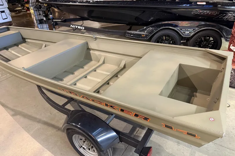 The Image of 2026 Tracker Grizzly 14 Jon boat on trailer, displayed indoors. - 0