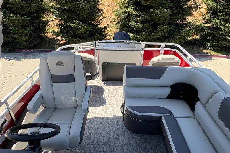 Slide: The Image of 2026 Sun Tracker Fishin' Barge 22 XP3 interior with seating and steering wheel. - 12