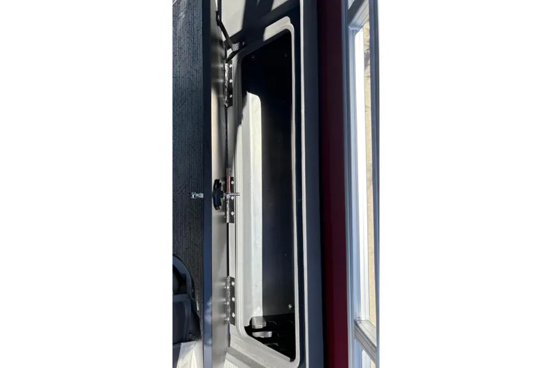Slide: The Image of Storage compartment of 2026 Sun Tracker Fishin' Barge 22 XP3 boat, open and empty. - 21