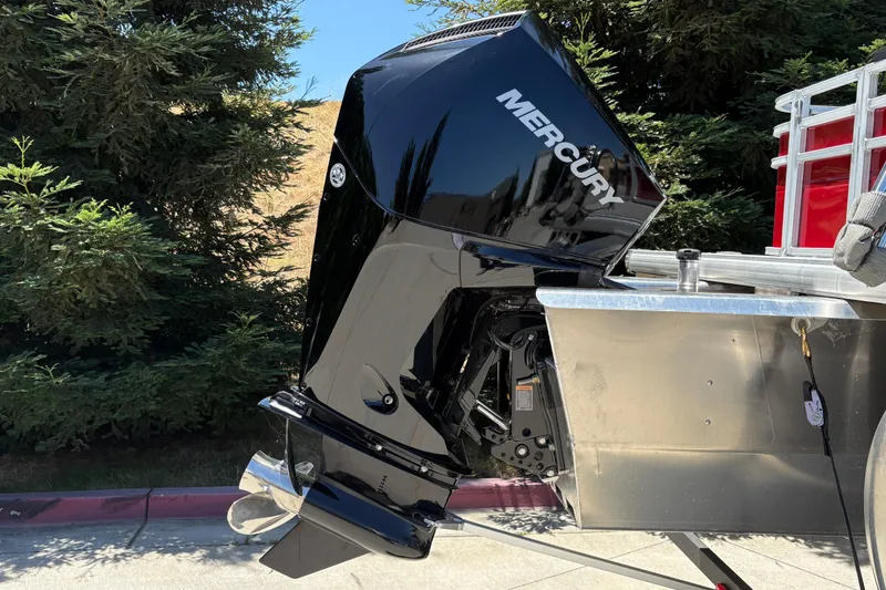 Slide: The Image of 2026 Sun Tracker Fishin' Barge 22 XP3 with Mercury outboard motor, parked outdoors. - 6