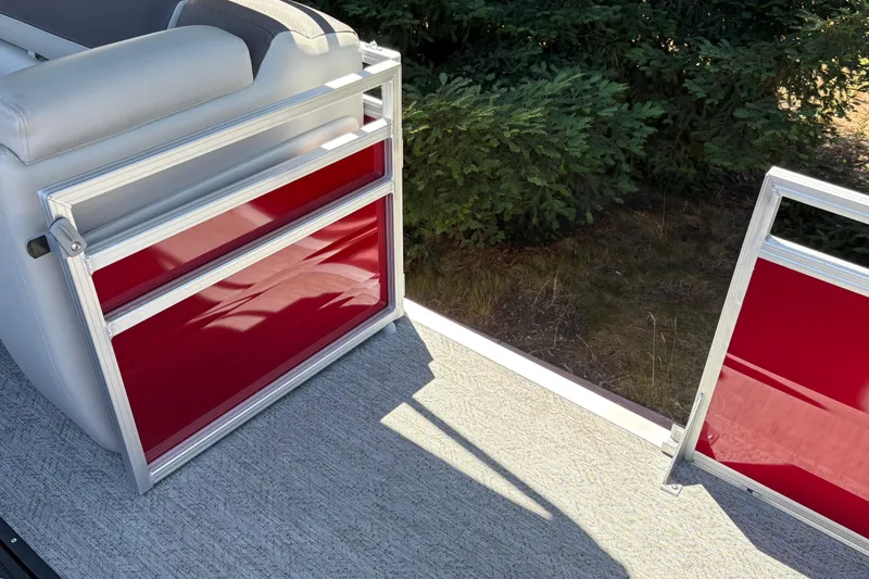 Slide: The Image of 2026 Sun Tracker Fishin' Barge 22 XP3, red paneling, gray seating, outdoor setting. - 43