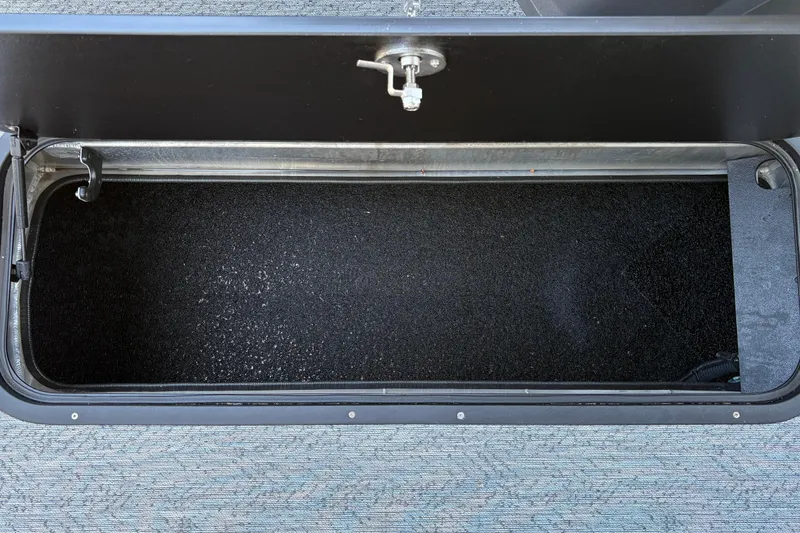 Slide: The Image of Storage compartment of 2026 Sun Tracker Fishin' Barge 22 XP3, open and empty. - 125