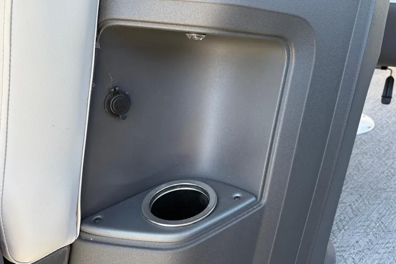 Slide: The Image of Cup holder and power outlet on 2026 Sun Tracker Fishin' Barge 22 XP3 boat interior. - 27
