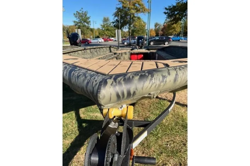 Slide: The Image of 2026 Tracker Grizzly 1756 T Marsh boat on trailer, camo design, parked outdoors. - 48