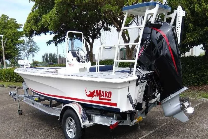 Slide: The Image of 2026 Mako 18 Pro Skiff Patriot Edition boat on trailer, parked outdoors. - 3