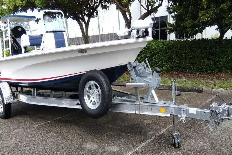 Slide: The Image of 2026 Mako 18 Pro Skiff Patriot Edition boat on trailer, parked outdoors. - 6