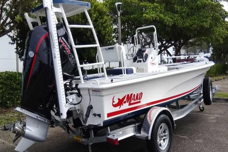 Slide: The Image of 2026 Mako 18 Pro Skiff Patriot Edition boat on trailer, featuring powerful outboard motor. - 8