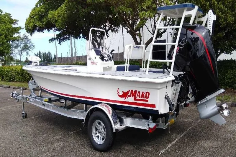 Slide: The Image of 2026 Mako 18 Pro Skiff Patriot Edition boat on trailer, parked outdoors. - 9