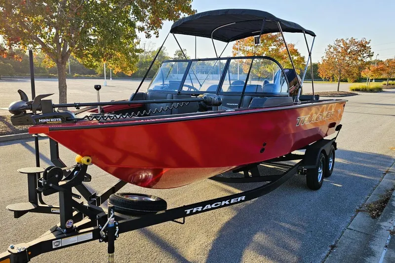 Slide: The Image of 2026 Tracker Targa V-19 Combo boat storage compartment with orange case inside. - 14