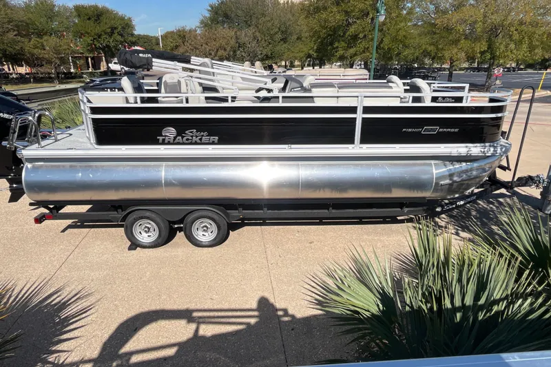 Slide: The Image of 2026 Sun Tracker Fishin' Barge 22 XP3 pontoon boat on trailer, parked outdoors. - 74