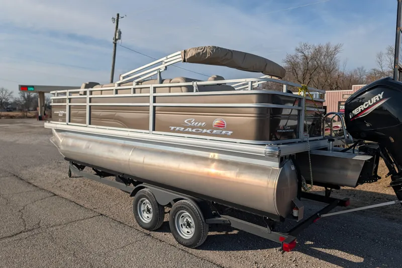 Slide: The Image of 2024 Sun Tracker SportFish 20 DLX pontoon boat on trailer, parked outdoors. - 65