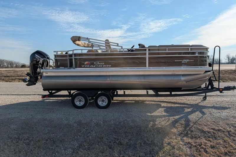 Slide: The Image of 2024 Sun Tracker SportFish 20 DLX pontoon boat on trailer, parked on a rural road. - 70
