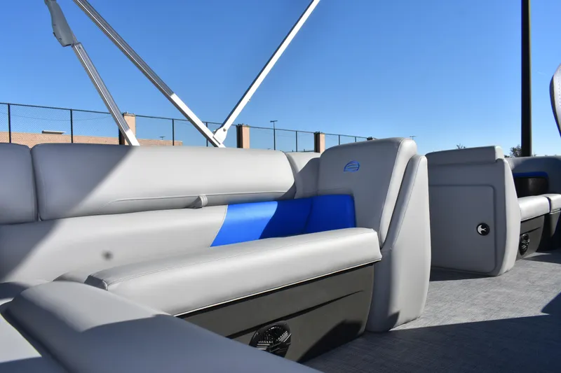Slide: The Image of 2026 Sun Tracker Party Barge 20 DLX interior with gray and blue seating under clear sky. - 18