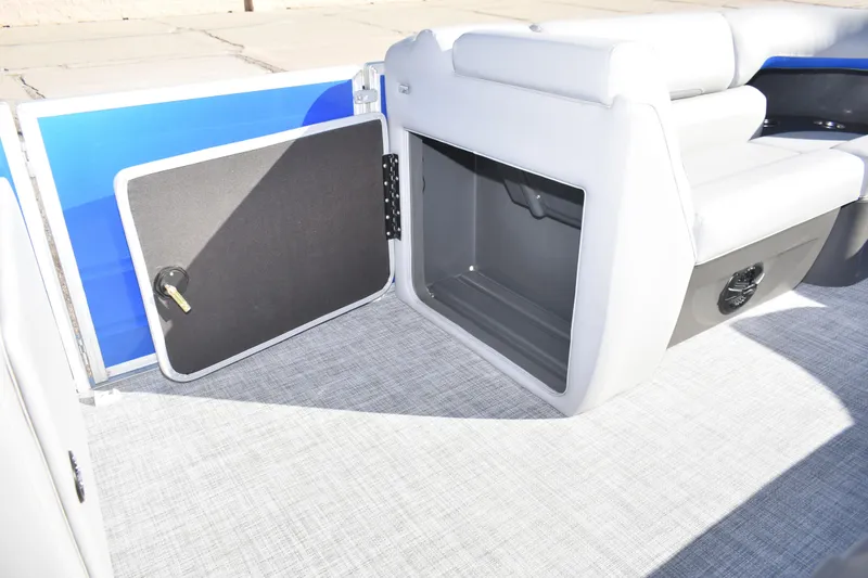 Slide: The Image of 2026 Sun Tracker Party Barge 20 DLX storage compartment with open door, showcasing interior space. - 20