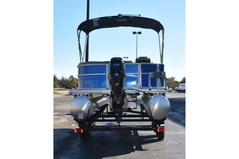 Slide: The Image of 2026 Sun Tracker Party Barge 20 DLX pontoon boat, rear view, parked outdoors. - 4