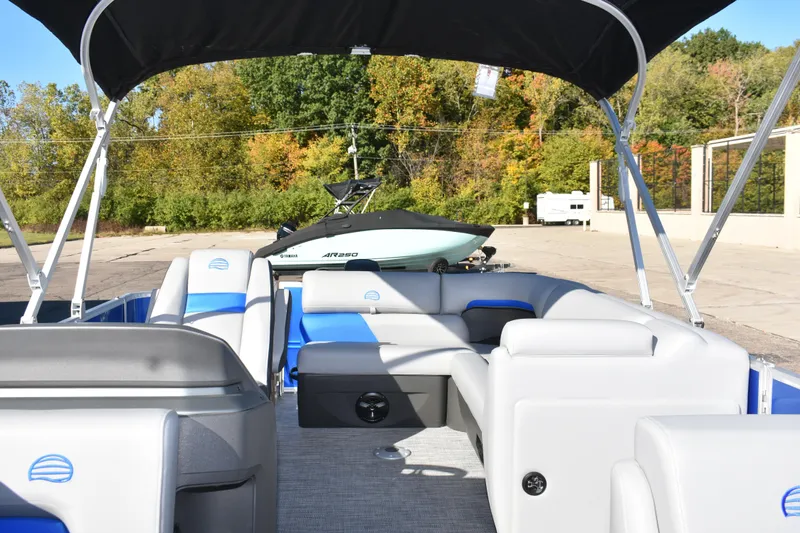 Slide: The Image of 2026 Sun Tracker Party Barge 20 DLX interior with seating, under a canopy, outdoors. - 7