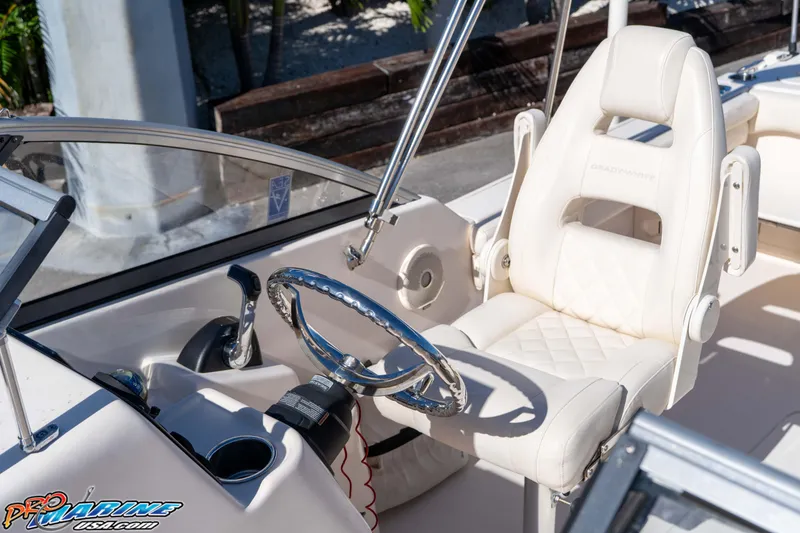 Slide: The Image of 2016 Grady-White Freedom 225 boat interior with steering wheel and captain's chair. - 32