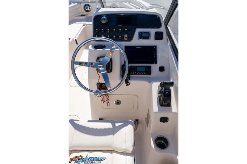 Slide: The Image of 2016 Grady-White Freedom 225 boat dashboard with steering wheel and control panel. - 38