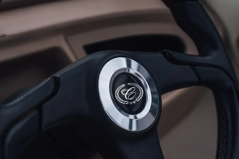 Slide: The Image of Steering wheel of a 2008 Cobalt 202 boat, featuring a sleek design and emblem. - 14