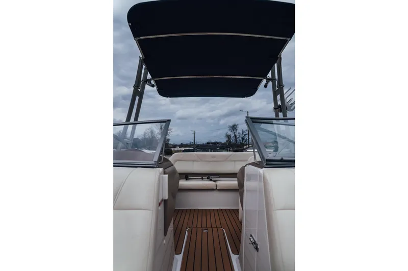 Slide: The Image of 2008 Cobalt 202 boat interior with canopy, featuring beige seating and wooden flooring. - 16