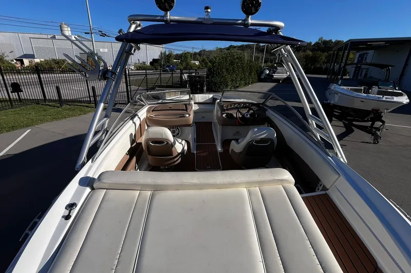 Slide: The Image of 2008 Cobalt 202 boat interior with seating and steering wheel, parked outdoors. - 23