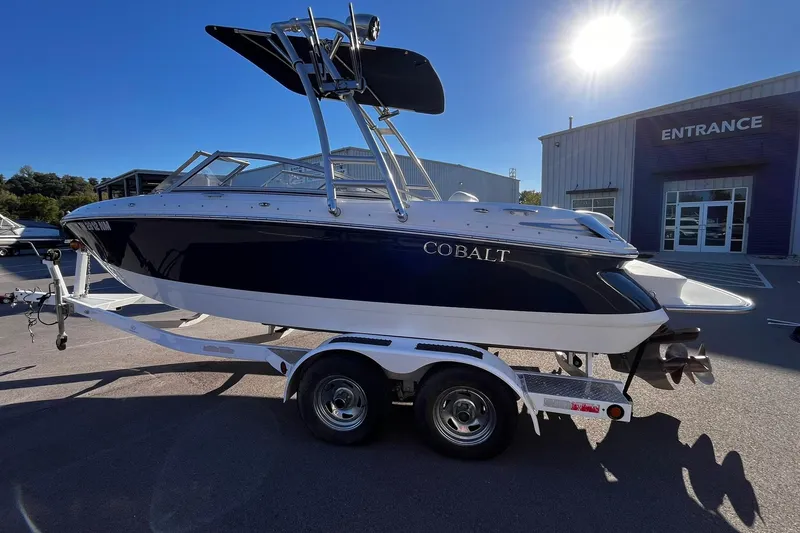 Slide: The Image of 2008 Cobalt 202 boat on trailer, parked outside a building under bright sunlight. - 3