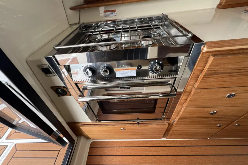 Slide: The Image of Luxury kitchen in 2025 Ranger Tugs R-27, featuring a modern stainless steel stove and oven. - 13