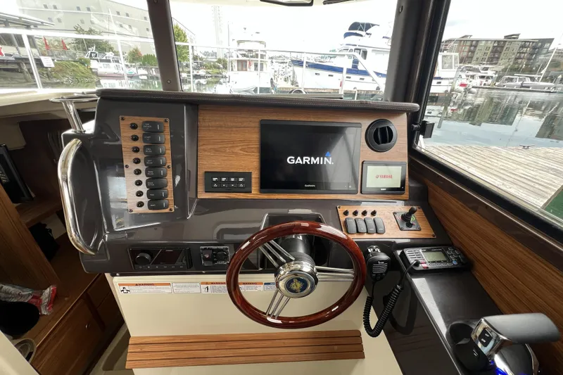 Slide: The Image of Helm of 2025 Ranger Tugs R-27 Luxury Edition with Garmin navigation system and wooden accents. - 16