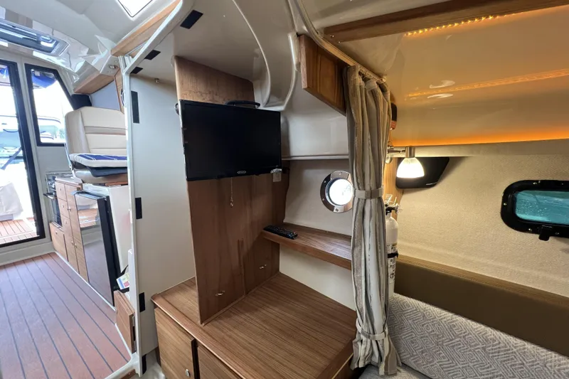 Slide: The Image of 2025 Ranger Tugs R-27 Luxury Edition interior with TV, seating, and wood finishes. - 21