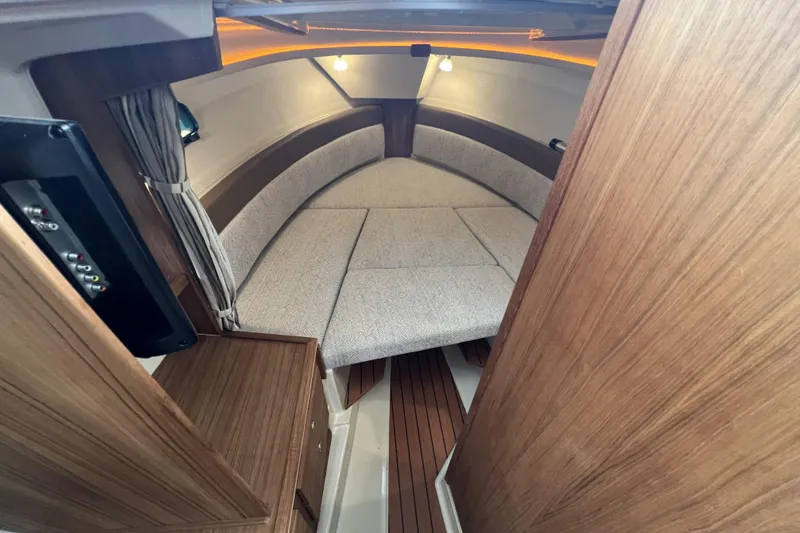 Slide: The Image of Interior of 2025 Ranger Tugs R-27 Luxury Edition, featuring cozy seating and wood accents. - 23