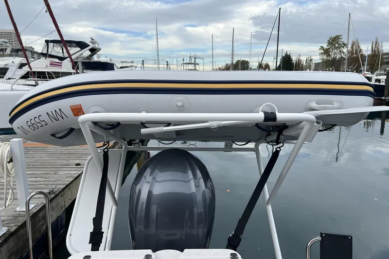 Slide: The Image of 2025 Ranger Tugs R-27 Luxury Edition with mounted inflatable boat at marina. - 26