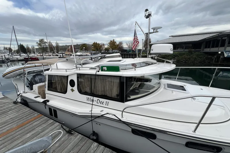 Slide: The Image of 2025 Ranger Tugs R-27 Luxury Edition docked at marina under cloudy sky. - 3
