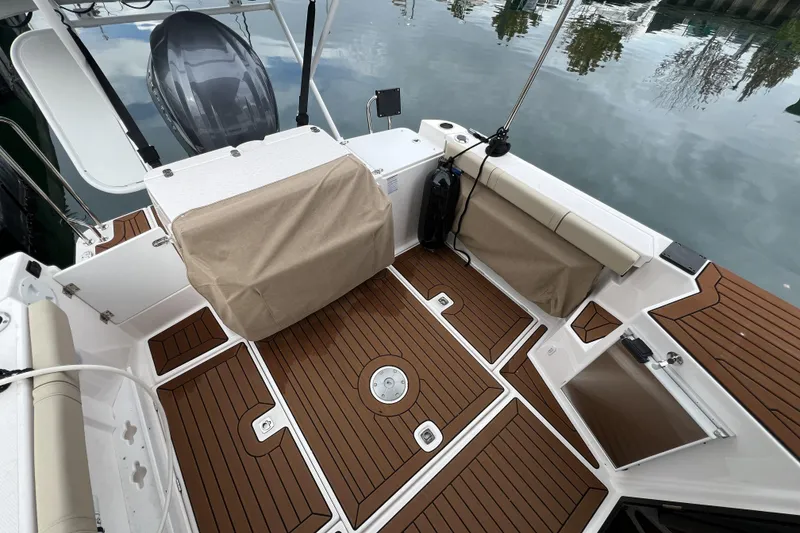 Slide: The Image of 2025 Ranger Tugs R-27 Luxury Edition boat deck with teak flooring and covered seating. - 8