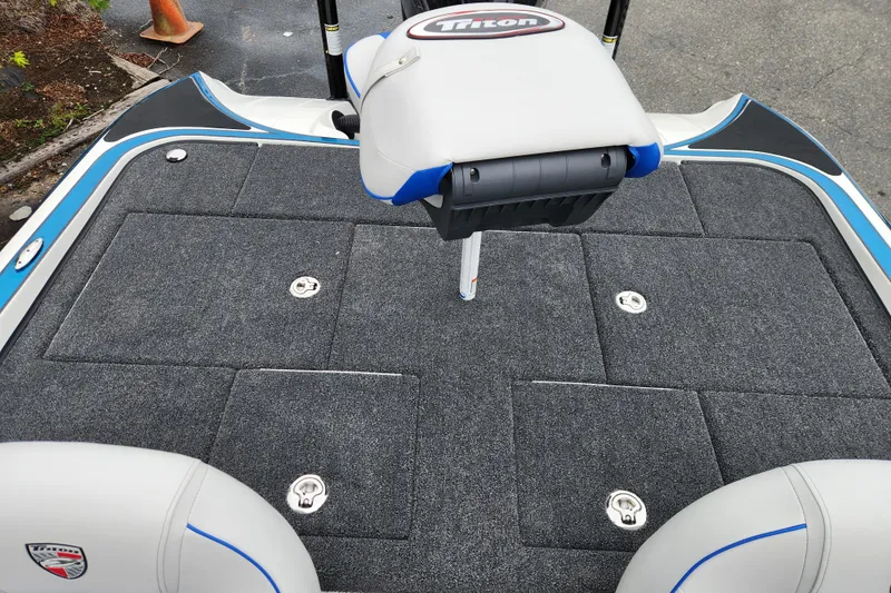 Slide: The Image of 2026 Triton 19 TrX Patriot boat deck with seating and storage compartments. - 15
