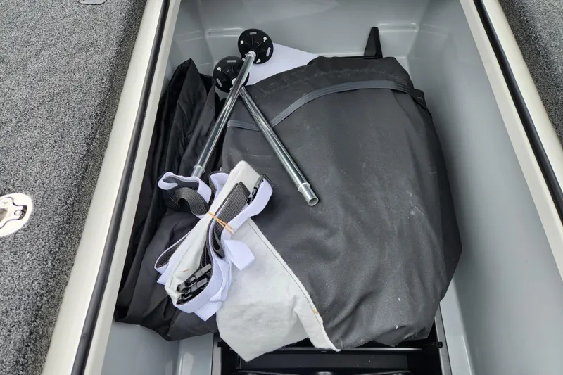 Slide: The Image of Storage compartment of 2026 Triton 19 TrX Patriot boat with equipment and accessories. - 16