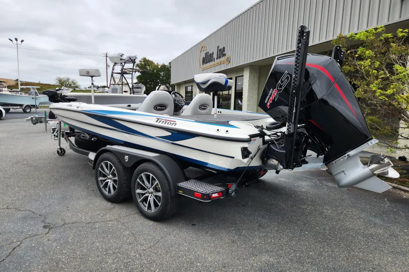 Slide: The Image of 2026 Triton 19 TrX Patriot boat with powerful outboard motor, parked on a trailer. - 2