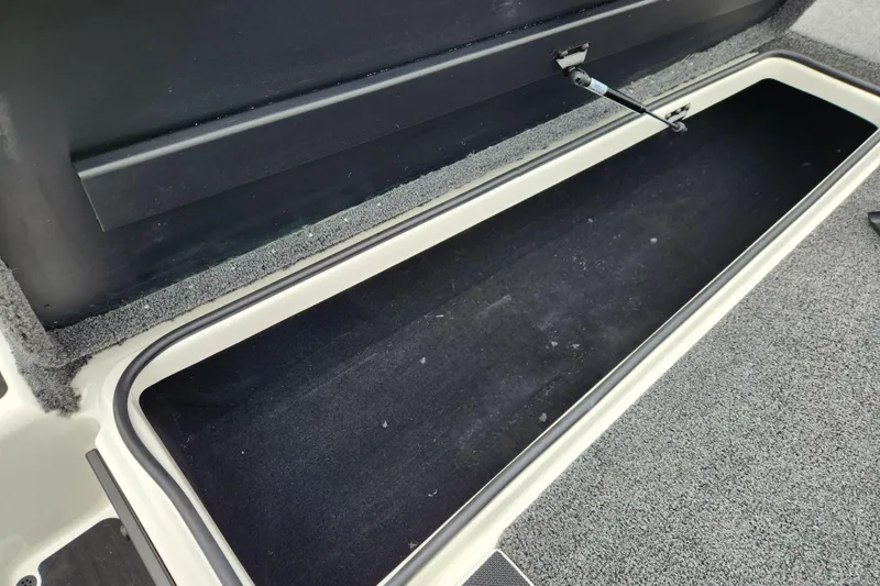 Slide: The Image of Open storage compartment in 2026 Triton 19 TrX Patriot boat. - 9