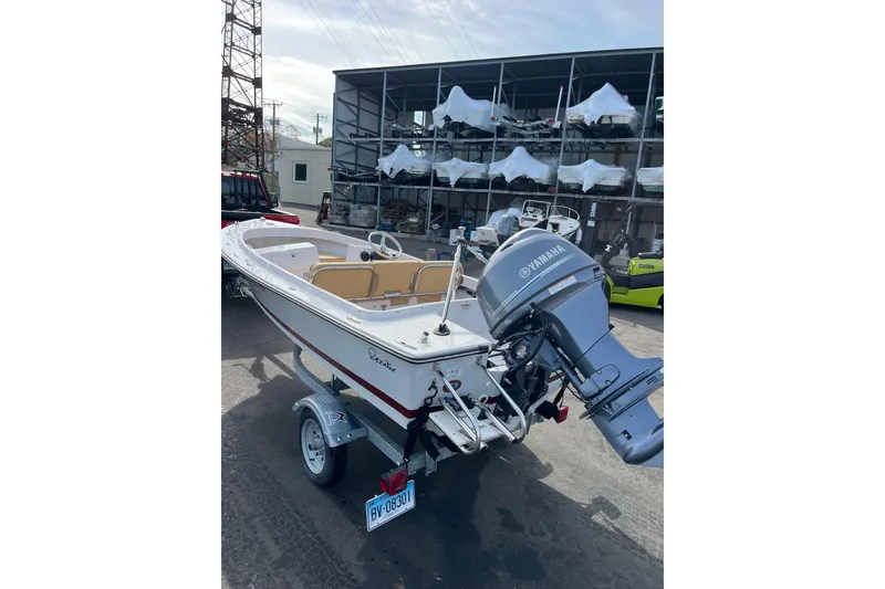 The Image of 2023 Rossiter 14 boat with Yamaha motor on trailer, parked in marina storage area. - 1
