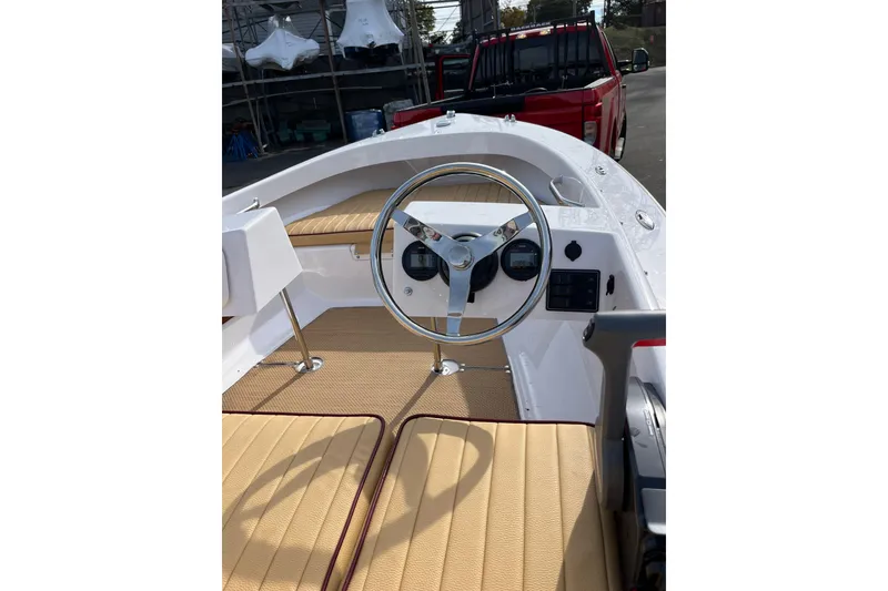 Slide: The Image of 2023 Rossiter 14 boat interior with steering wheel and tan seating. - 7